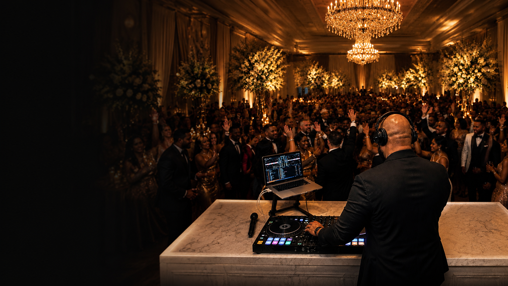 DJ GMi performing at a wedding reception, guests dancing under chandeliers